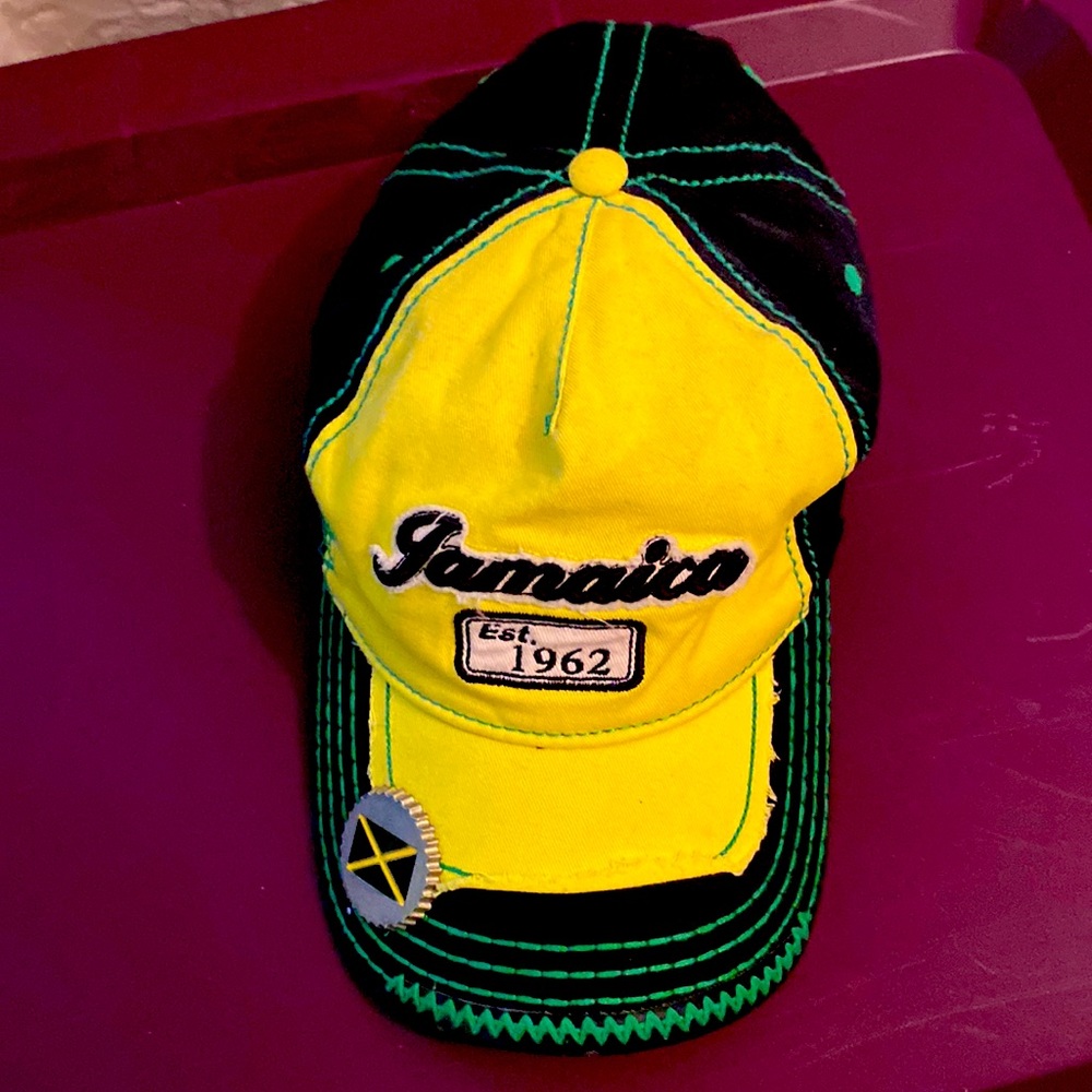 Adjustable cloth cap w/ bottle opener under bill, and Jamaica flag accents.